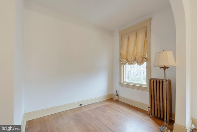 empty room featuring radiator and light wood-type flooring