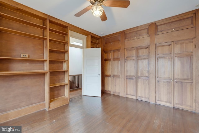 unfurnished bedroom with ceiling fan and wood-type flooring