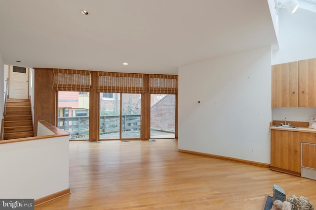 unfurnished living room with sink and light hardwood / wood-style flooring