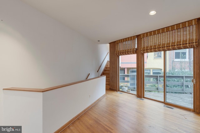 unfurnished room with a wealth of natural light and light hardwood / wood-style flooring