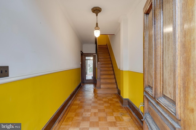 hall with ornamental molding and light parquet floors