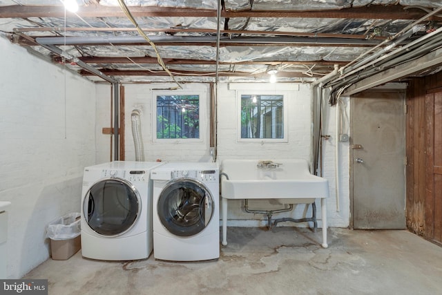 clothes washing area featuring sink and washer and clothes dryer