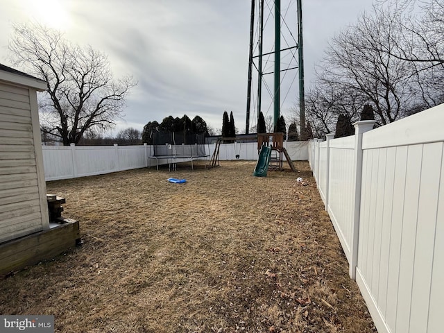 view of yard with a playground and a trampoline