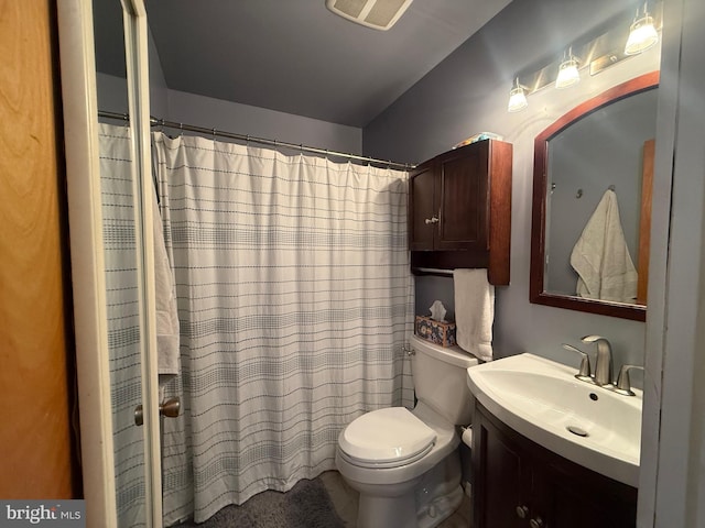 bathroom featuring walk in shower, vanity, and toilet