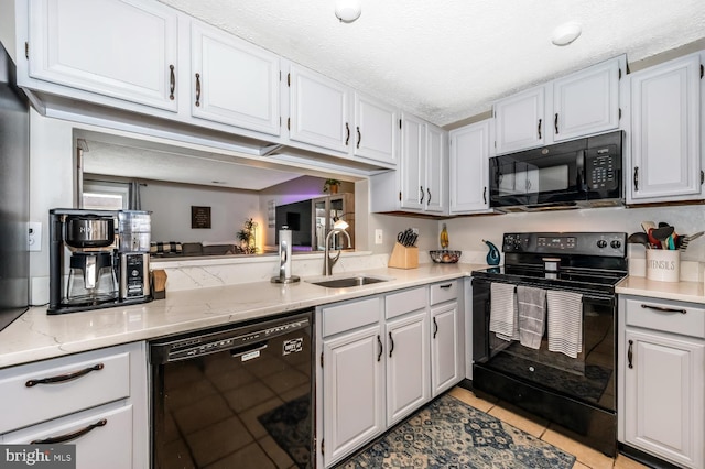 kitchen with white cabinetry, light tile patterned floors, sink, and black appliances