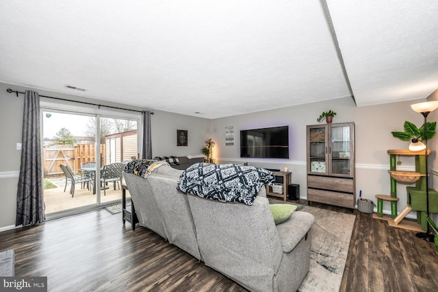 living room with dark wood-type flooring and a textured ceiling