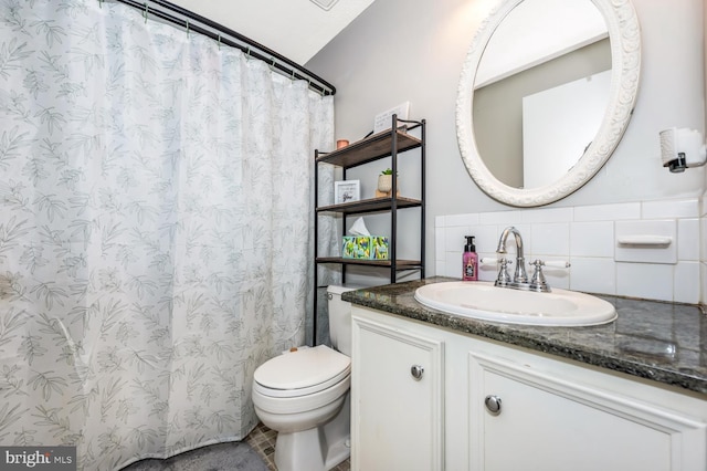 bathroom with vanity, toilet, and backsplash