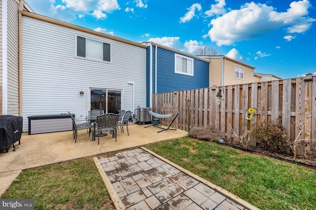 rear view of house featuring a patio, a yard, and cooling unit