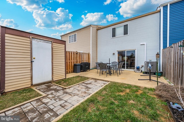 rear view of house with a patio area and a storage unit