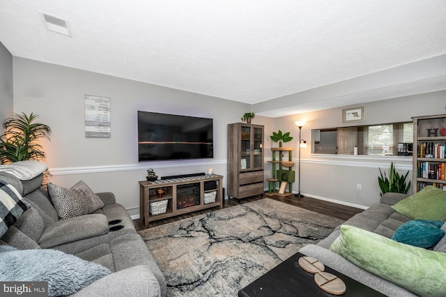 living room with hardwood / wood-style floors and a textured ceiling