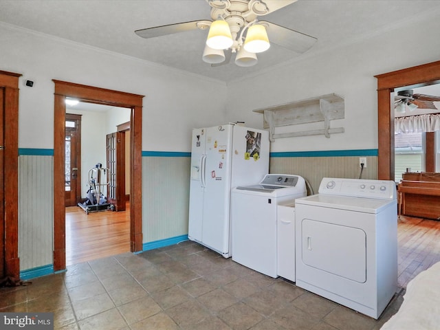 laundry area featuring ceiling fan, independent washer and dryer, ornamental molding, and wood walls