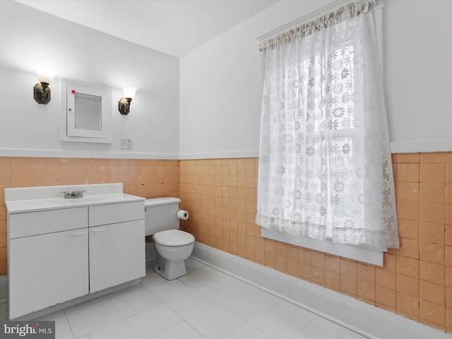 bathroom featuring tile walls, vanity, tile patterned flooring, and toilet