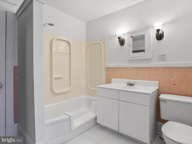 full bathroom with tub / shower combination, tile patterned flooring, tile walls, vanity, and toilet