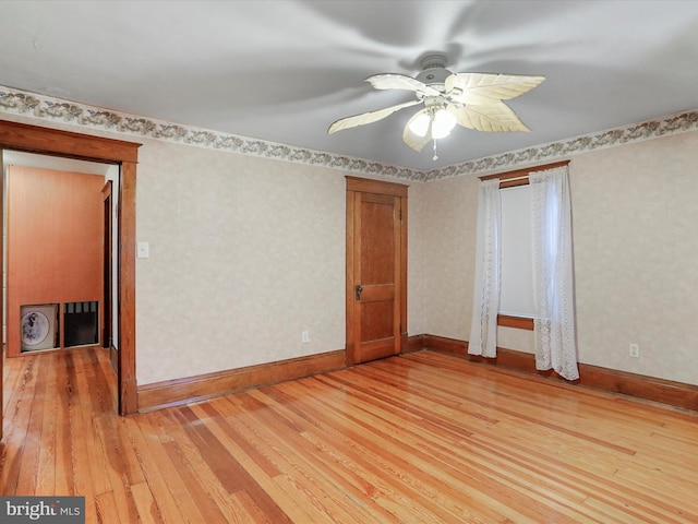 empty room with ceiling fan and light hardwood / wood-style floors