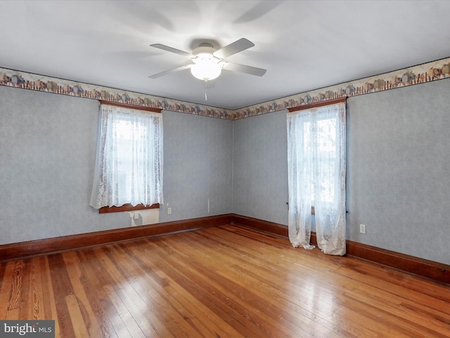 unfurnished room featuring a wealth of natural light, ceiling fan, and light hardwood / wood-style flooring