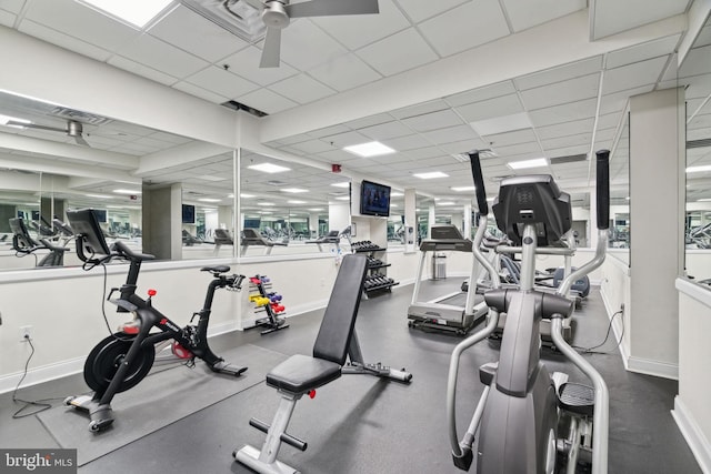 workout area with a paneled ceiling and ceiling fan