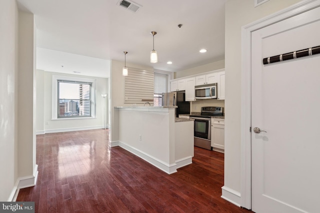 kitchen featuring white cabinetry, decorative light fixtures, dark wood-type flooring, and appliances with stainless steel finishes