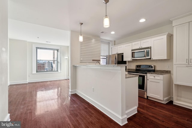 kitchen featuring stainless steel appliances, white cabinetry, light stone countertops, and pendant lighting