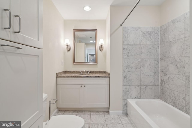 full bathroom with tiled shower / bath, vanity, and toilet