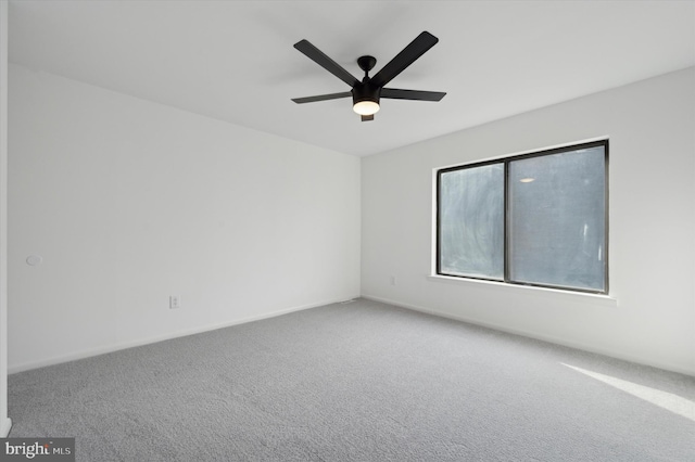 empty room featuring ceiling fan and carpet