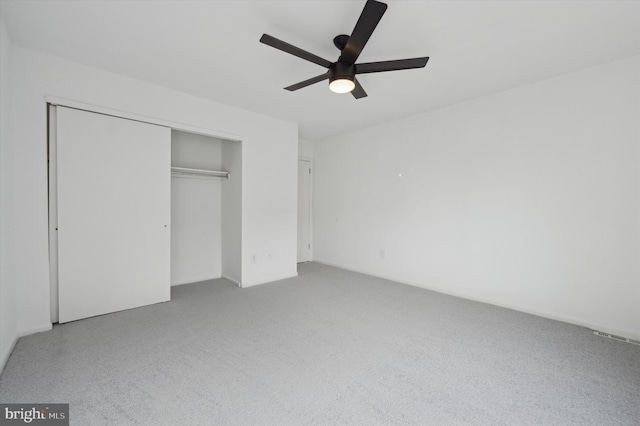 unfurnished bedroom with a closet, ceiling fan, and carpet