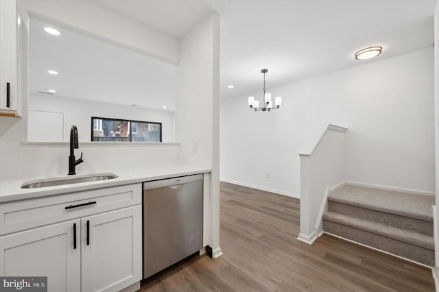 kitchen featuring pendant lighting, dishwasher, sink, white cabinets, and dark hardwood / wood-style flooring