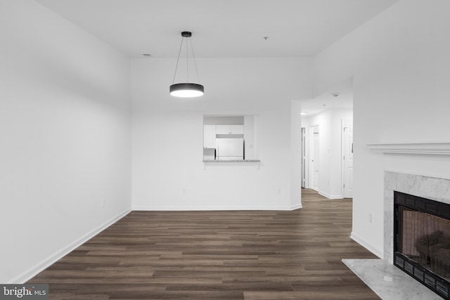 unfurnished living room with a premium fireplace and dark hardwood / wood-style floors