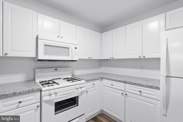 kitchen with light stone counters, white appliances, decorative backsplash, and white cabinets