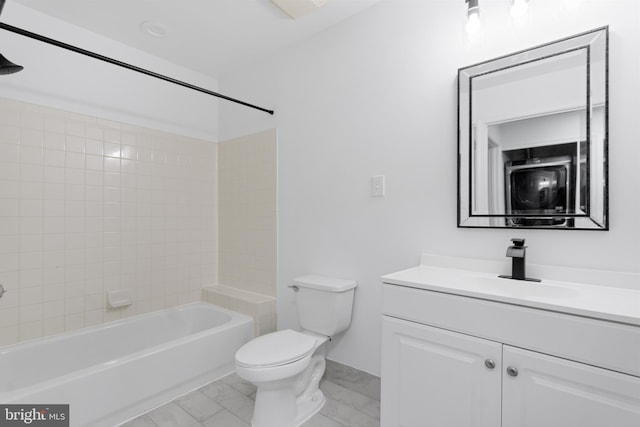 full bathroom with tiled shower / bath, vanity, and toilet