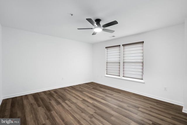 spare room featuring ceiling fan and dark hardwood / wood-style flooring