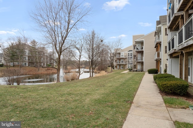 view of community featuring a water view and a lawn