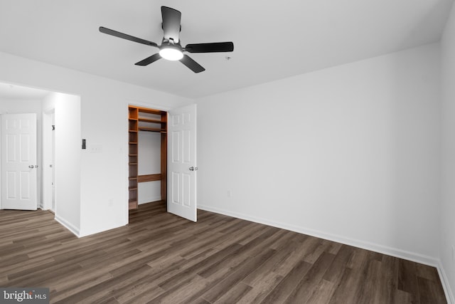 unfurnished bedroom with a walk in closet, dark hardwood / wood-style floors, ceiling fan, and a closet