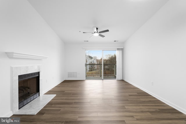 unfurnished living room featuring dark hardwood / wood-style flooring, a high end fireplace, and ceiling fan