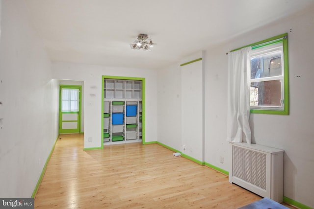 spare room featuring radiator and light wood-type flooring