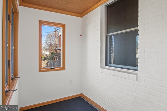 empty room with brick wall and wood ceiling