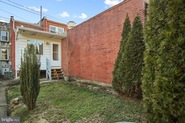 rear view of property featuring a lawn