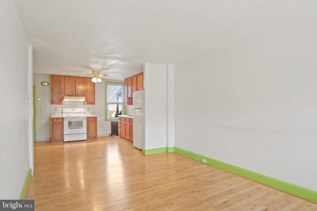 kitchen featuring tasteful backsplash, ceiling fan, white appliances, and light hardwood / wood-style floors