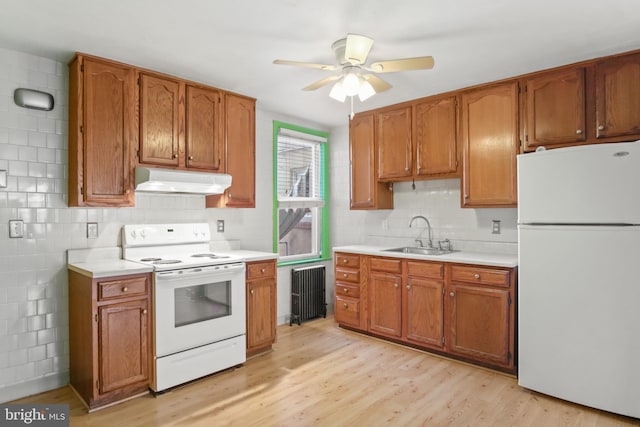 kitchen featuring sink, white appliances, radiator, tasteful backsplash, and light hardwood / wood-style floors