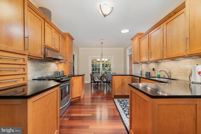 kitchen with sink, hanging light fixtures, ornamental molding, appliances with stainless steel finishes, and kitchen peninsula