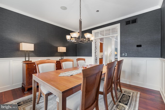 dining space featuring crown molding, dark hardwood / wood-style flooring, and a notable chandelier