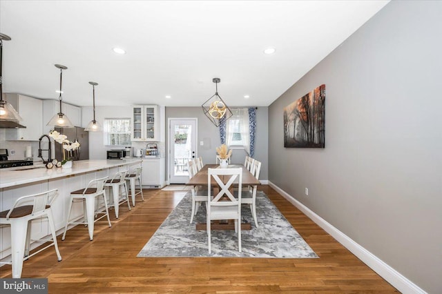 dining space with recessed lighting, wood finished floors, and baseboards