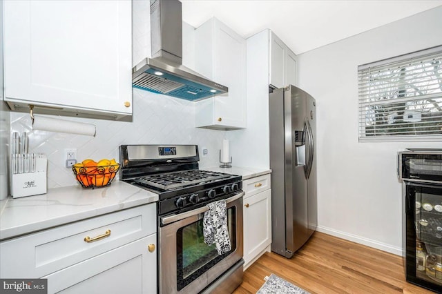 kitchen featuring light stone counters, decorative backsplash, appliances with stainless steel finishes, white cabinets, and exhaust hood