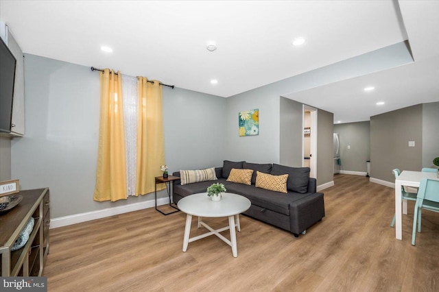 living room with recessed lighting, light wood-style flooring, and baseboards