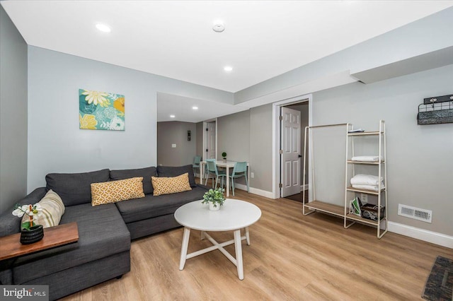 living room with light wood finished floors, recessed lighting, visible vents, and baseboards