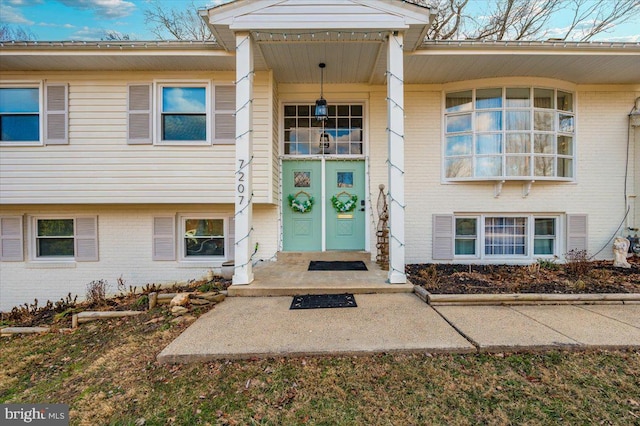 entrance to property featuring brick siding