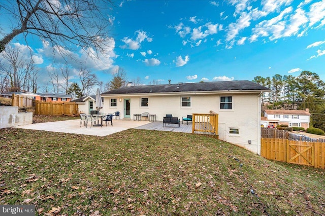 rear view of house featuring a patio area, fence, and a lawn