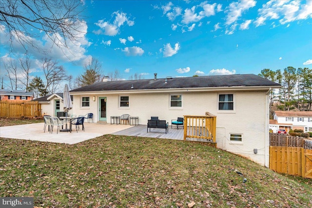 back of property featuring a yard, fence, a patio, and brick siding