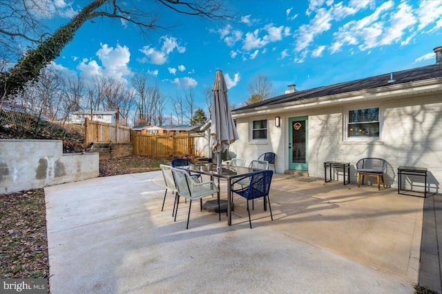 view of patio featuring outdoor dining space and fence