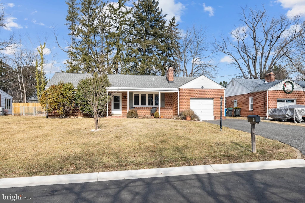 ranch-style house featuring a garage and a front lawn