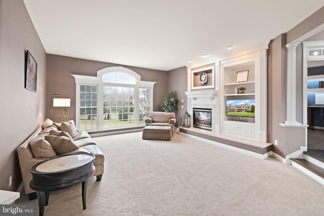 living room featuring built in features, decorative columns, and carpet